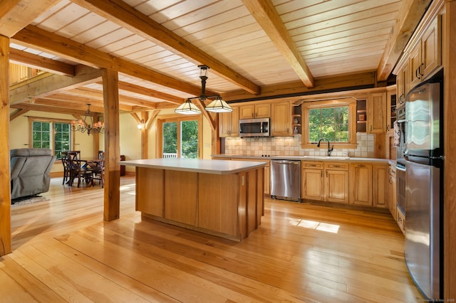 18 Sandpiper Ln, East Lyme, CT 06333 - kitchen with appliances with stainless steel finishes, light countertops, a kitchen island, light wood finished floors, and a wooden ceiling with exposed beams