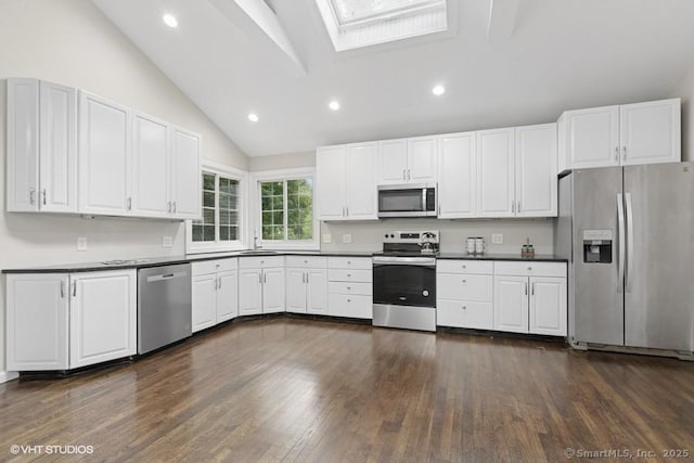 6 Kingsbury Rd, Norwalk, CT 06851 - kitchen with stainless steel appliances, vaulted ceiling, dark wood-type flooring, dark countertops, and a skylight