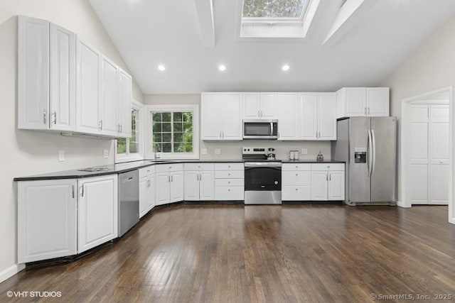 6 Kingsbury Rd, Norwalk, CT 06851 - kitchen featuring stainless steel appliances, vaulted ceiling, dark countertops, a skylight, and dark wood-style flooring