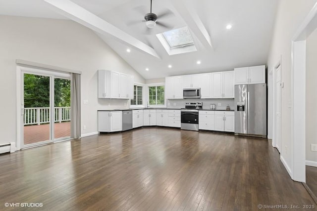 6 Kingsbury Rd, Norwalk, CT 06851 - kitchen with appliances with stainless steel finishes, a skylight, a ceiling fan, high vaulted ceiling, and white cabinetry