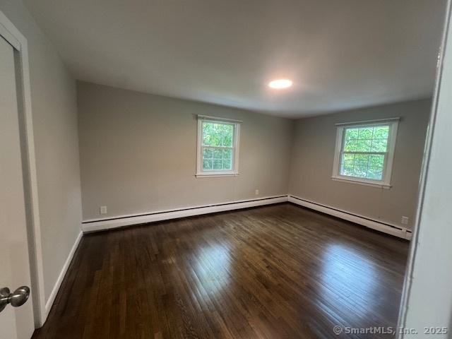 6 Kingsbury Rd, Norwalk, CT 06851 - empty room with healthy amount of natural light, wood finished floors, a baseboard radiator, and a baseboard heating unit
