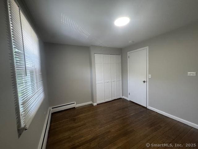 6 Kingsbury Rd, Norwalk, CT 06851 - unfurnished bedroom with dark wood-style flooring, a baseboard radiator, and a closet