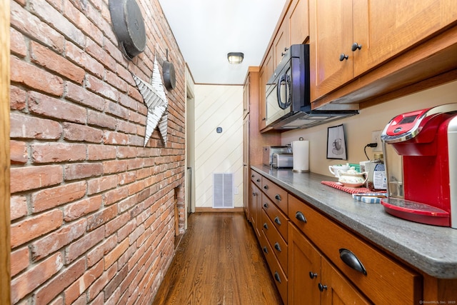 26 Skyview Ter, Bristol, CT 06010 - kitchen with brick wall, dark wood-style flooring, brown cabinets, and dark countertops