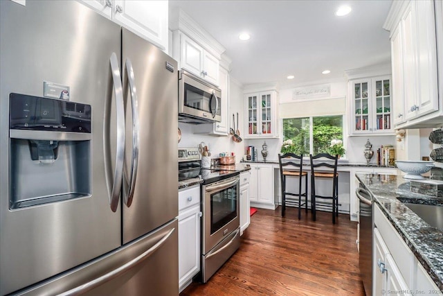 17 Harbour Vlg Unit F, Branford, CT 06405 - kitchen with appliances with stainless steel finishes, white cabinets, glass insert cabinets, dark stone countertops, and recessed lighting