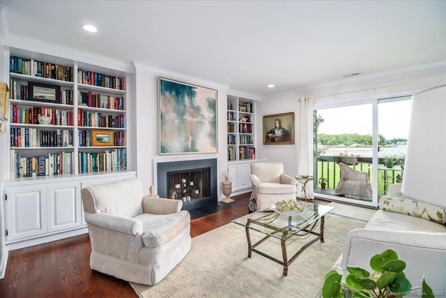 17 Harbour Vlg Unit F, Branford, CT 06405 - living room with ornamental molding, wood finished floors, a fireplace with flush hearth, built in features, and recessed lighting