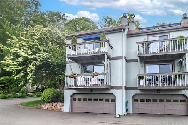 17 Harbour Vlg Unit F, Branford, CT 06405 - view of front facade with a balcony, an attached garage, a chimney, and driveway