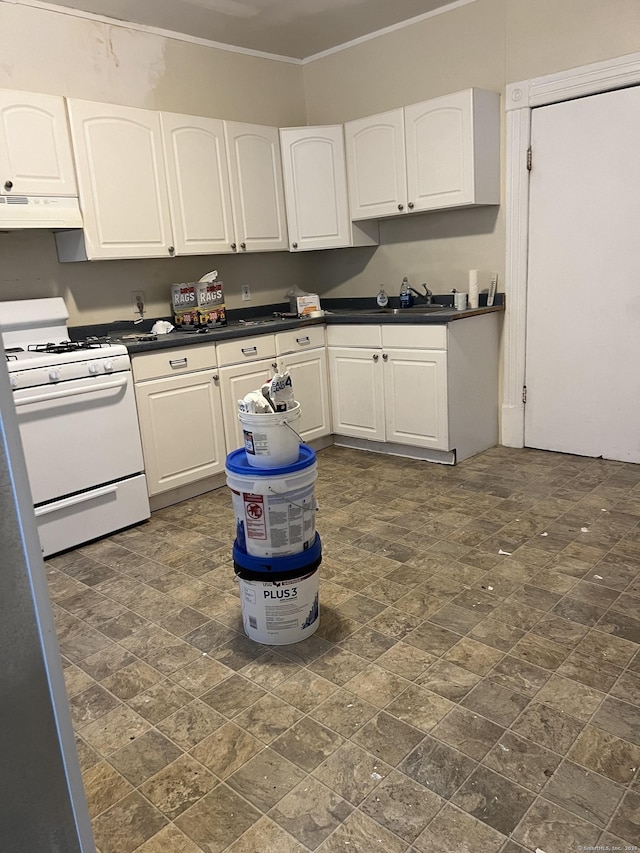 183 Franklin St, Norwich, CT 06360 - kitchen with white range with gas stovetop, under cabinet range hood, dark countertops, white cabinets, and crown molding