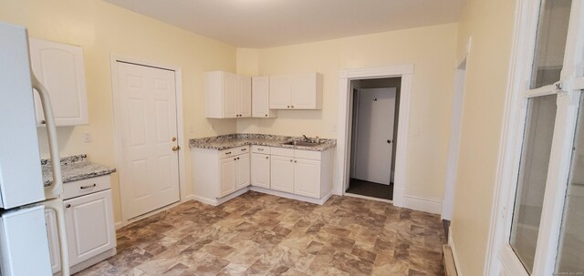 183 Franklin St, Norwich, CT 06360 - kitchen featuring stone finish floors, light stone countertops, and white cabinets