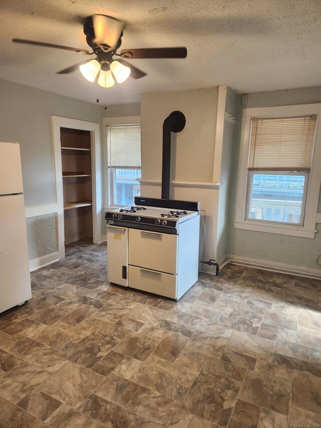 293 Central Ave, Norwich, CT 06360 - kitchen with white appliances, healthy amount of natural light, a textured ceiling, ceiling fan, and stone finish floors
