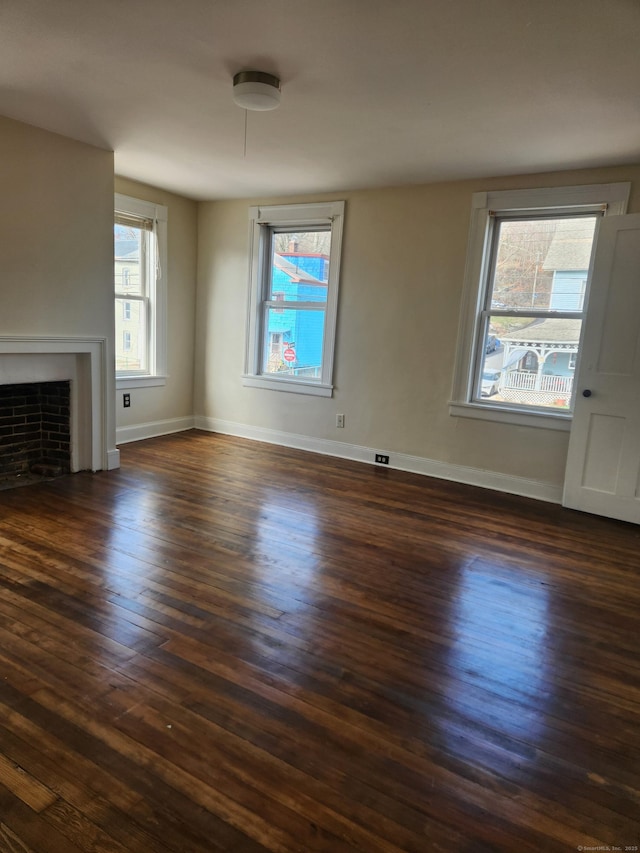 293 Central Ave, Norwich, CT 06360 - unfurnished living room with dark wood-style floors, healthy amount of natural light, and a fireplace