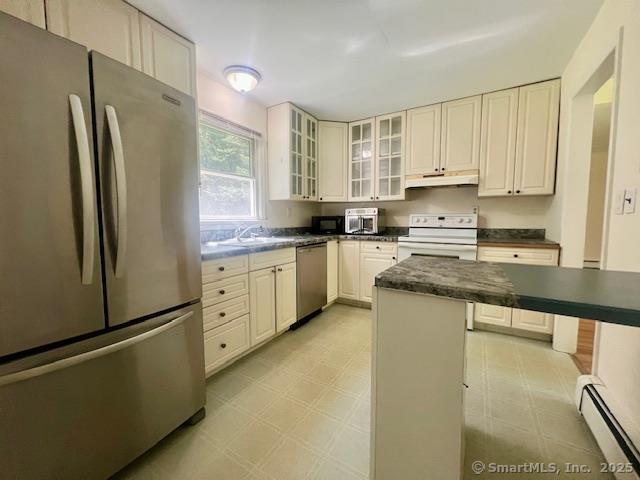 70 Watermelon Hill Rd, Carmel, NY 10541 - kitchen featuring appliances with stainless steel finishes, under cabinet range hood, light floors, baseboard heating, and dark countertops