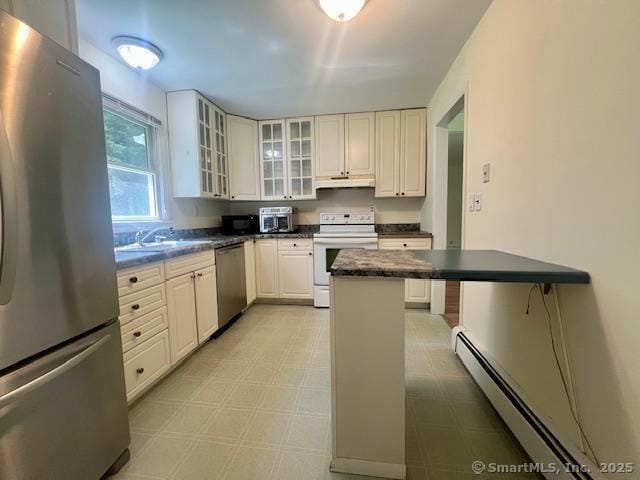 70 Watermelon Hill Rd, Carmel, NY 10541 - kitchen with stainless steel appliances, a baseboard heating unit, under cabinet range hood, dark countertops, and light flooring