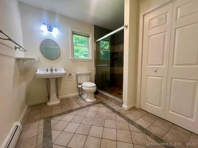 70 Watermelon Hill Rd, Carmel, NY 10541 - bathroom with baseboard heating, a stall shower, inlaid floor details, and tile patterned flooring