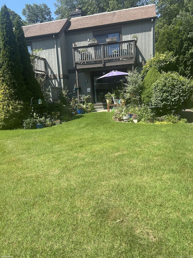 7 Harbour Vlg Unit A, Branford, CT 06405 - back of house featuring a lawn, a balcony, a chimney, and roof with shingles