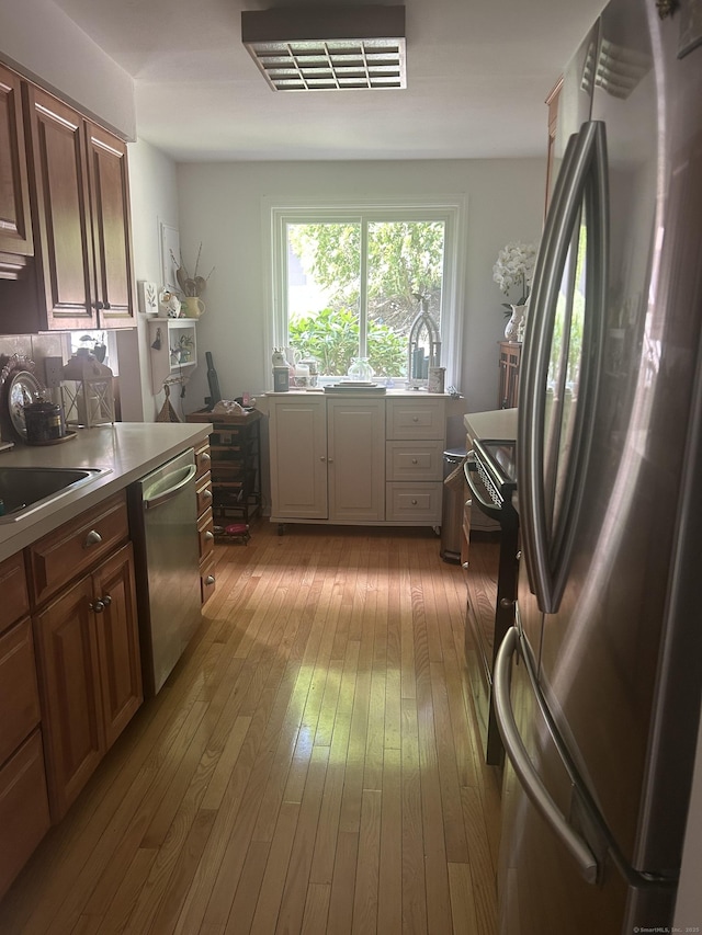 7 Harbour Vlg Unit A, Branford, CT 06405 - kitchen with appliances with stainless steel finishes, hardwood / wood-style flooring, and light countertops