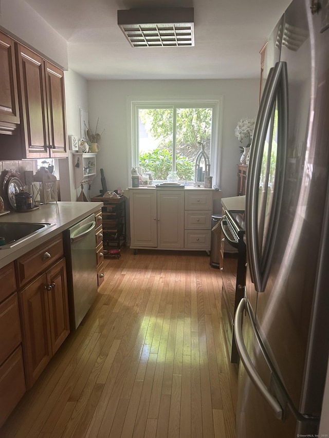7 Harbour Vlg Unit A, Branford, CT 06405 - kitchen featuring appliances with stainless steel finishes, hardwood / wood-style flooring, and light countertops