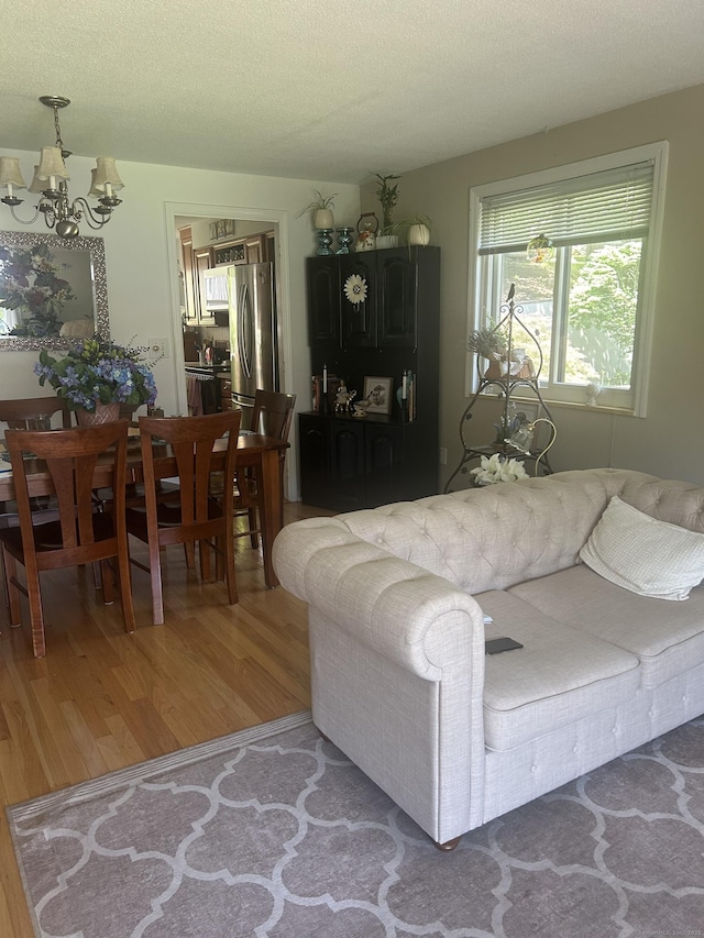 7 Harbour Vlg Unit A, Branford, CT 06405 - living room featuring a chandelier, light wood-type flooring, and a textured ceiling
