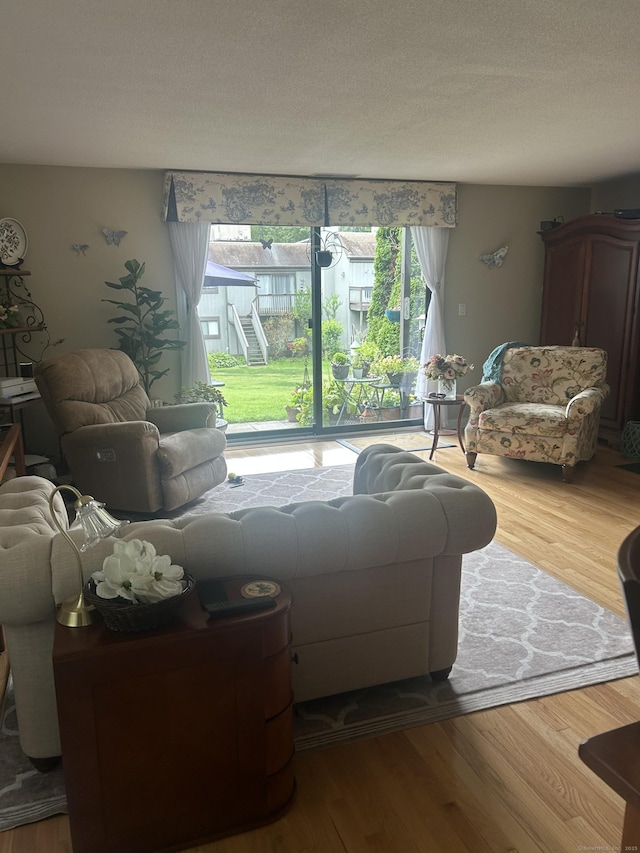 7 Harbour Vlg Unit A, Branford, CT 06405 - living area featuring plenty of natural light, wood finished floors, and a textured ceiling