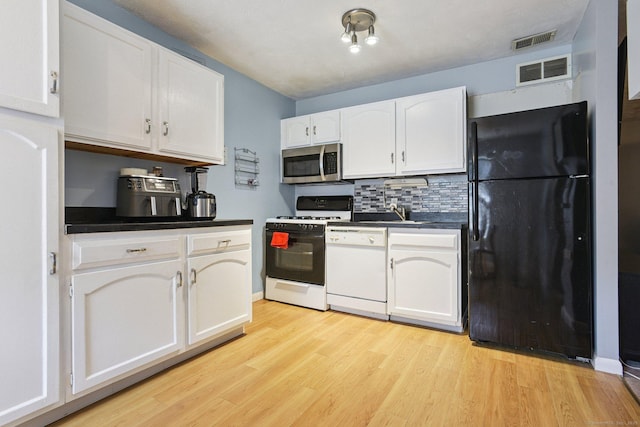 11 Cedar Ct Unit C, East Haven, CT 06513 - kitchen with white appliances, dark countertops, white cabinets, and light wood-type flooring