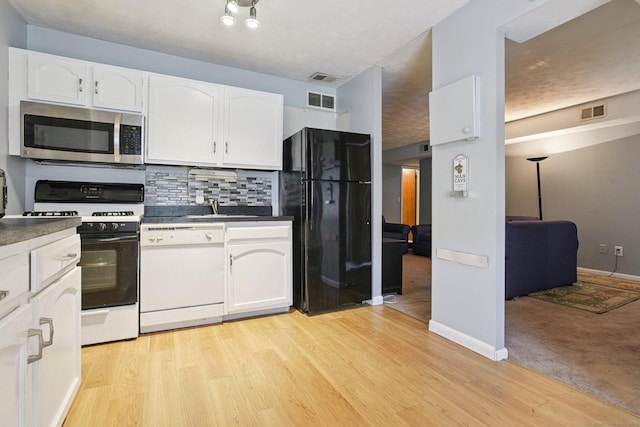 11 Cedar Ct Unit C, East Haven, CT 06513 - kitchen with white appliances, white cabinets, tasteful backsplash, and dark countertops
