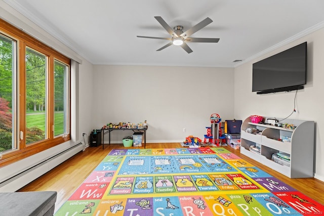 475 Pine Tree Dr, Orange, CT 06477 - recreation room featuring a baseboard heating unit, ceiling fan, ornamental molding, and wood finished floors