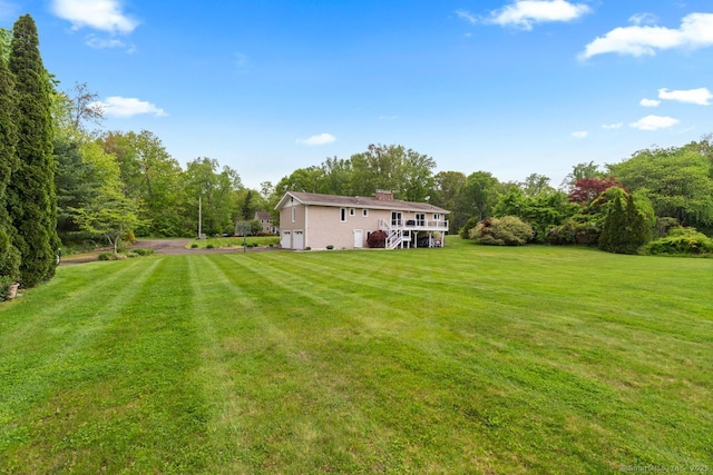 475 Pine Tree Dr, Orange, CT 06477 - view of green lawn featuring an attached garage and stairs