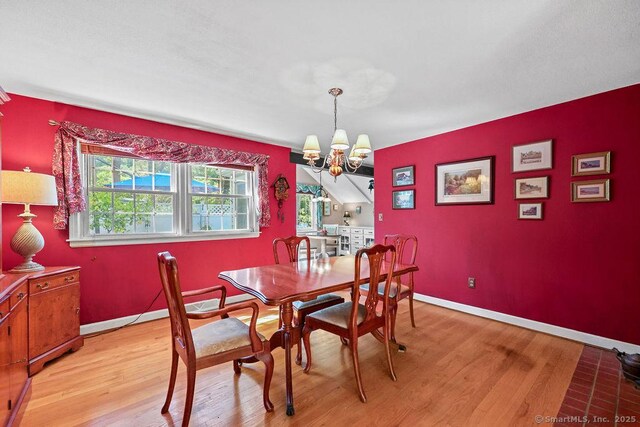 18 Chestnut Hill Rd, Simsbury, CT 06092 - dining area featuring light wood-style floors, a chandelier, and an accent wall