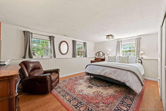 18 Chestnut Hill Rd, Simsbury, CT 06092 - bedroom with a wainscoted wall, light wood finished floors, and multiple windows