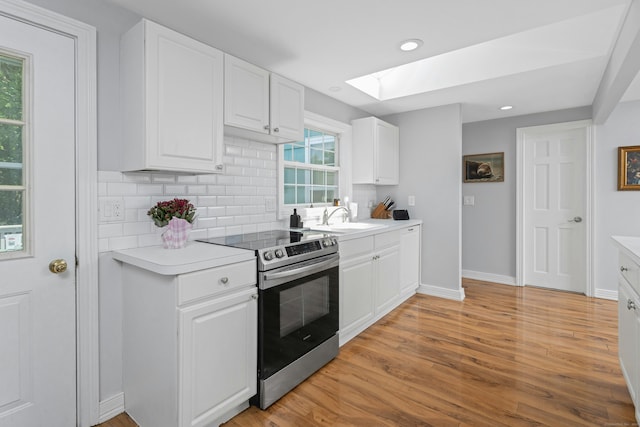 11 Margaret St, Norwalk, CT 06851 - kitchen featuring stainless steel range with electric cooktop, a skylight, decorative backsplash, light countertops, and recessed lighting