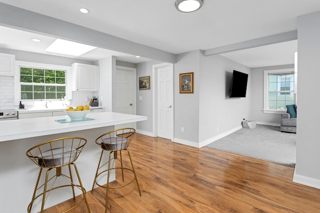 11 Margaret St, Norwalk, CT 06851 - kitchen with a kitchen breakfast bar, white cabinets, backsplash, light countertops, and recessed lighting