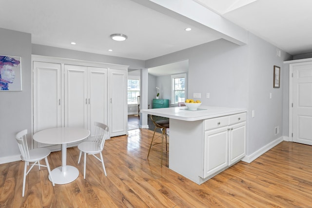 11 Margaret St, Norwalk, CT 06851 - kitchen featuring light wood-type flooring, white cabinetry, light countertops, a peninsula, and recessed lighting
