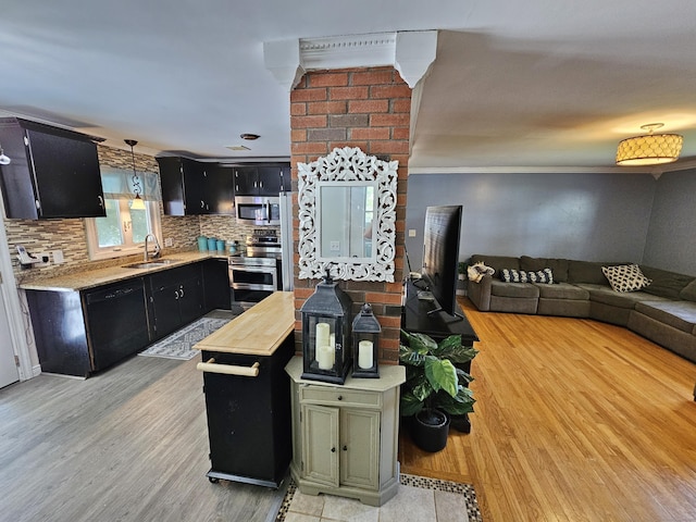 38 Sylvan Ave, Wallingford, CT 06492 - kitchen featuring appliances with stainless steel finishes, dark cabinetry, light countertops, light wood-style floors, and backsplash