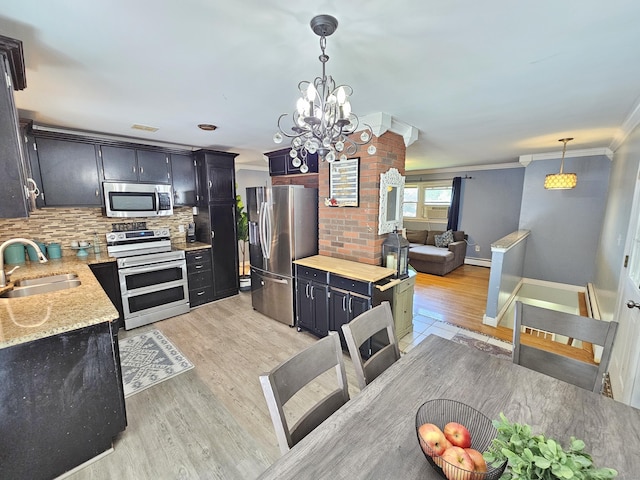 38 Sylvan Ave, Wallingford, CT 06492 - kitchen featuring stainless steel appliances, crown molding, tasteful backsplash, light wood finished floors, and a chandelier