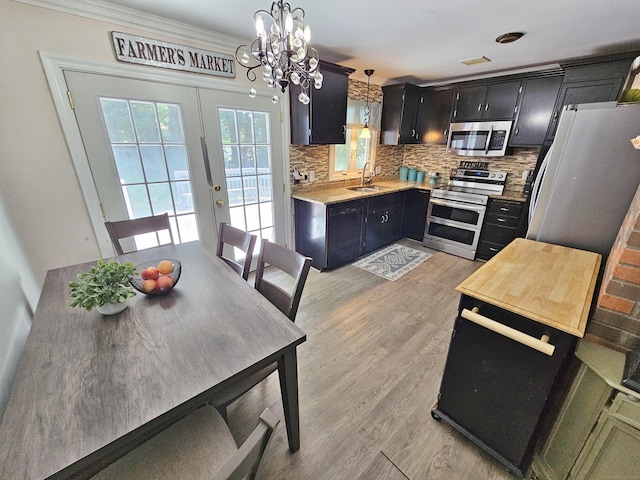 38 Sylvan Ave, Wallingford, CT 06492 - kitchen with stainless steel appliances, tasteful backsplash, dark cabinets, a chandelier, and light countertops