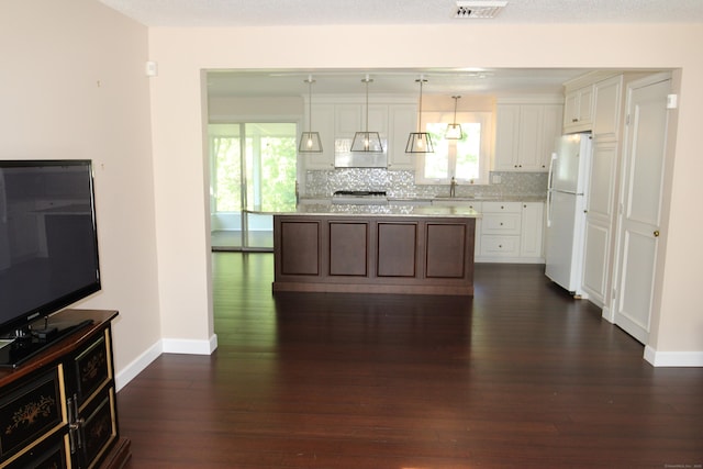 2337 Stanley St, New Britain, CT 06053 - kitchen with freestanding refrigerator, dark wood-style floors, white cabinets, and backsplash