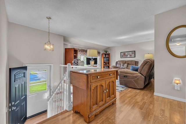 315 Judson Ave, Groton, CT 06355 - kitchen featuring brown cabinets, light wood-style flooring, a textured ceiling, hanging light fixtures, and a chandelier