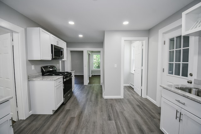 31 Chapman St, New Britain, CT 06051 - kitchen with black gas range oven, stainless steel microwave, dark wood finished floors, white cabinetry, and recessed lighting