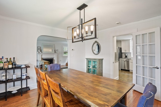 2 Clearview Ave, Norwalk, CT 06851 - dining area featuring wood finished floors, crown molding, a fireplace, a chandelier, and arched walkways