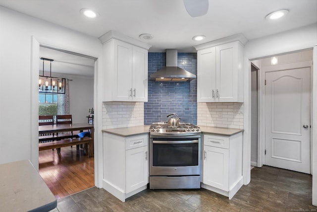 2 Clearview Ave, Norwalk, CT 06851 - kitchen featuring wall chimney range hood, gas range, white cabinetry, dark wood finished floors, and tasteful backsplash