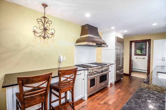 1384 N Benson Rd, Fairfield, CT 06824 - kitchen featuring wall chimney range hood, premium appliances, a chandelier, white cabinets, and recessed lighting