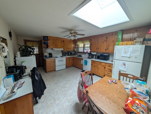 56 Mitchell St, New Britain, CT 06053 - kitchen featuring white appliances, a skylight, light countertops, light flooring, and brown cabinetry