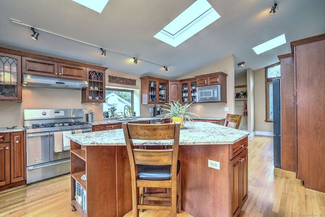 150 Westwood Rd, New Haven, CT 06515 - kitchen with appliances with stainless steel finishes, under cabinet range hood, a skylight, track lighting, and a center island