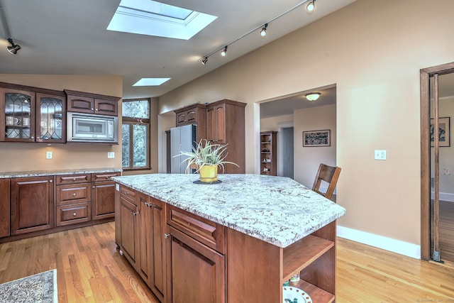 150 Westwood Rd, New Haven, CT 06515 - kitchen with a skylight, freestanding refrigerator, stainless steel microwave, open shelves, and light wood finished floors