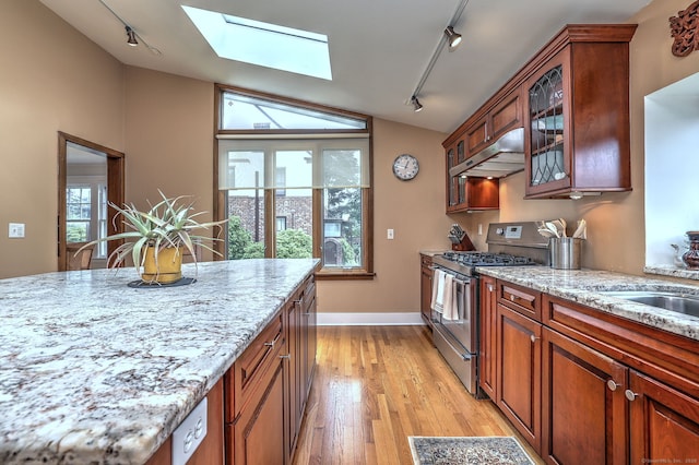 150 Westwood Rd, New Haven, CT 06515 - kitchen with stainless steel gas range oven, rail lighting, under cabinet range hood, lofted ceiling, and a skylight