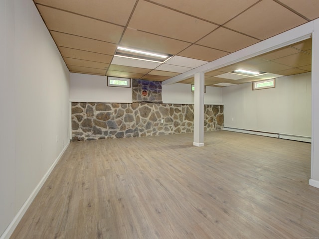 185 Hope Valley Rd, Hebron, CT 06231 - below grade area featuring a baseboard heating unit, wood finished floors, and a paneled ceiling