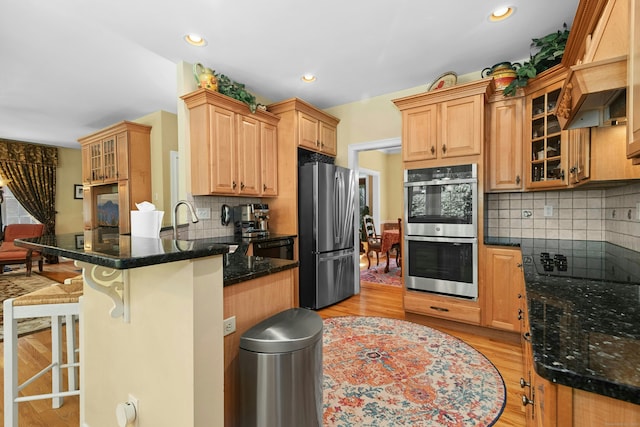 20 Lisbon Ter, Oxford, CT 06478 - kitchen with black appliances, a breakfast bar, a peninsula, custom exhaust hood, and decorative backsplash