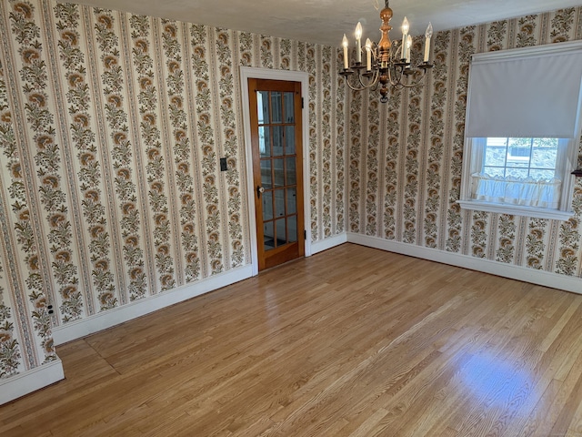 28 Maplerow Ave, Waterbury, CT 06705 - unfurnished room with wallpapered walls, wood finished floors, and a chandelier