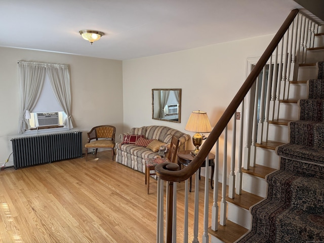 28 Maplerow Ave, Waterbury, CT 06705 - living room with radiator heating unit, wood finished floors, cooling unit, and stairs