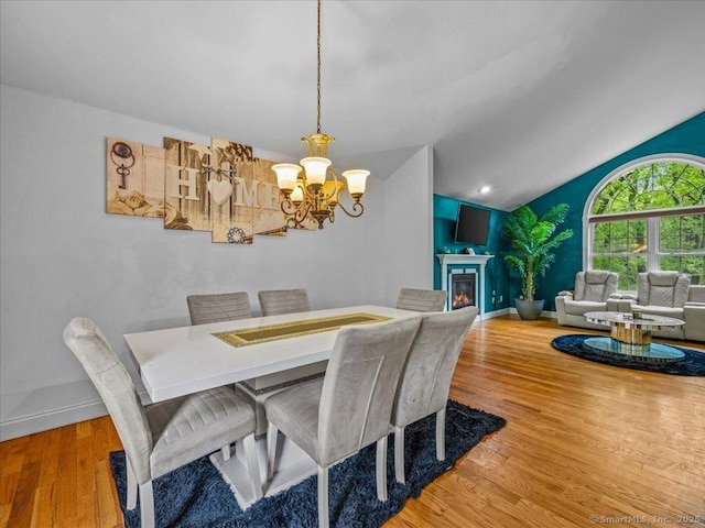 126 Conrad Dr, New Haven, CT 06515 - dining room with a chandelier, wood finished floors, lofted ceiling, and a lit fireplace