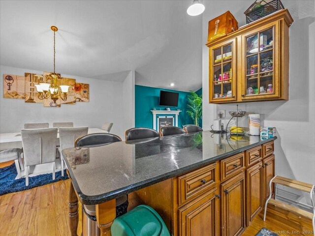 126 Conrad Dr, New Haven, CT 06515 - kitchen featuring a chandelier, brown cabinetry, light wood-type flooring, open floor plan, and decorative light fixtures